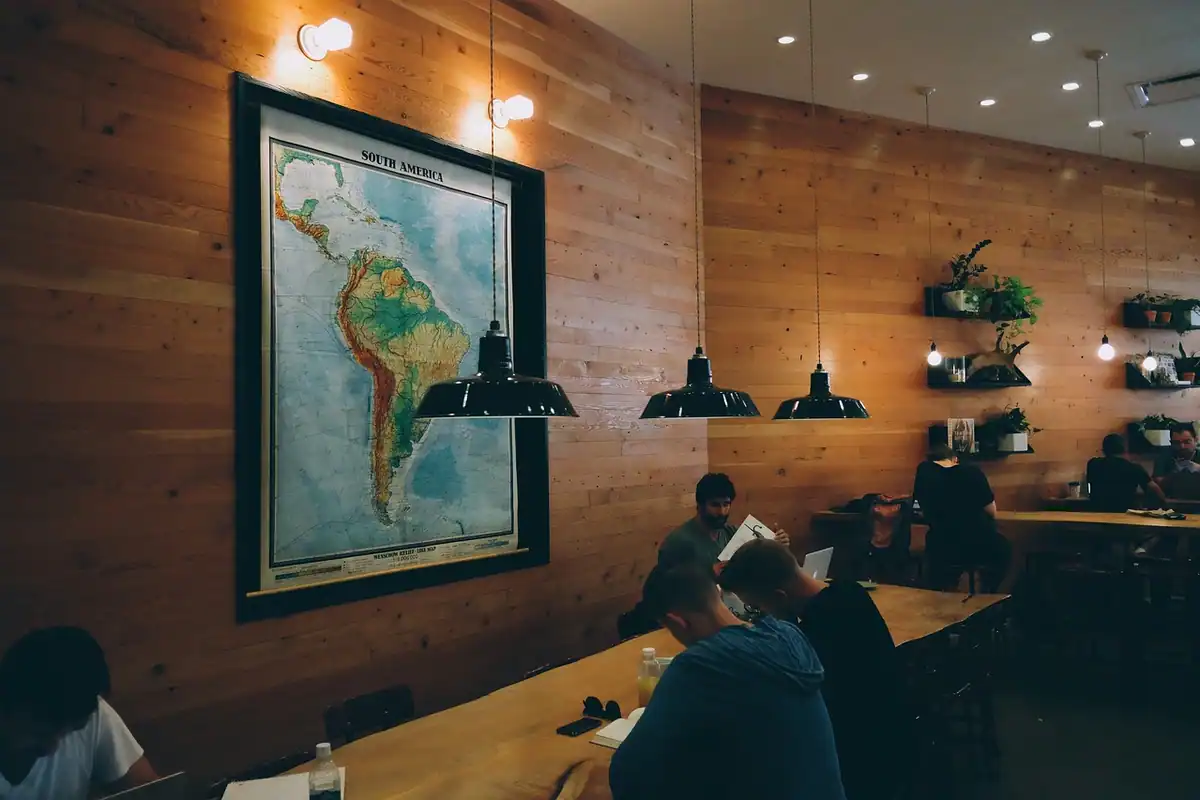 Fondatori lucrează într-un spațiu comun de tip coworking, sub o hartă mare agățată pe perete