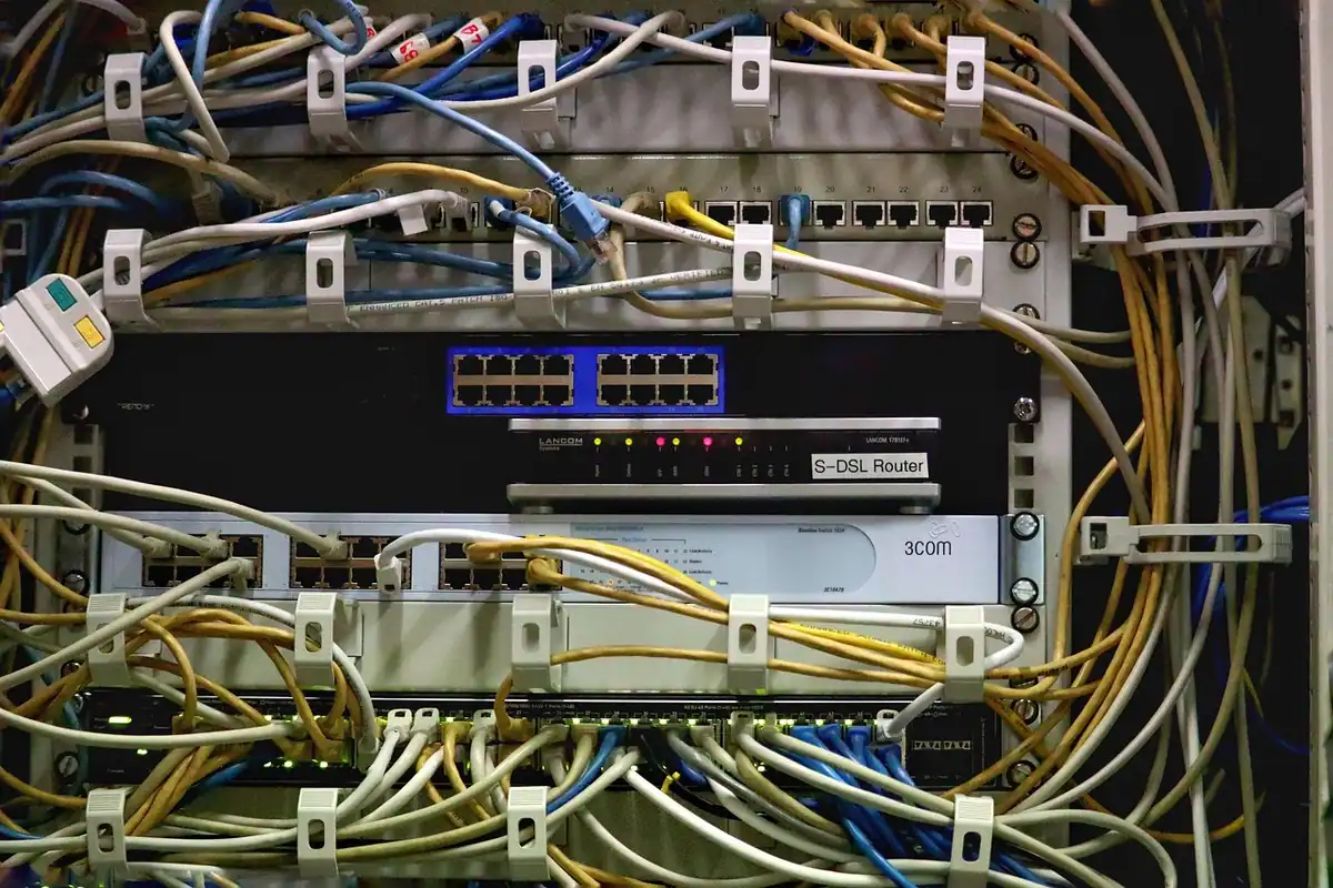 Un dulap de server plin de cabluri împletite și porturi de rețea conectate