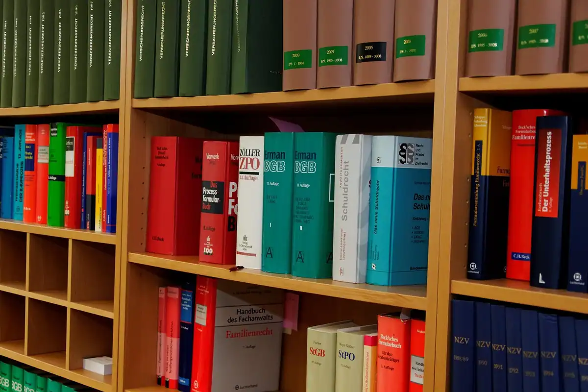 O bibliotecă din lemn plină de cărți de drept și dosare, pentru clauzele contractului